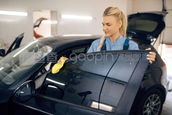 用海绵清洗汽车内部的女性垫圈